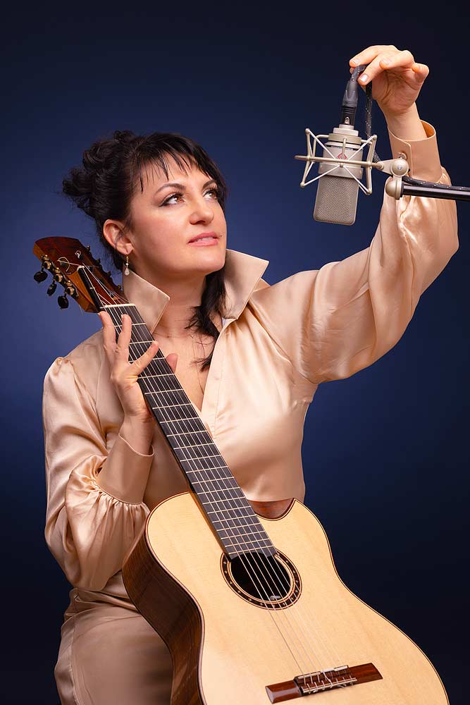 Porträt der Gitarristin und Sängerin Ruslana Lucia mit Mikrofon und ihrer 7-saitigen Gitarre